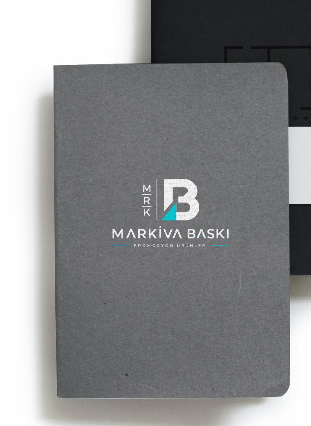 Kapağına beyaz logo basılmış gri defter